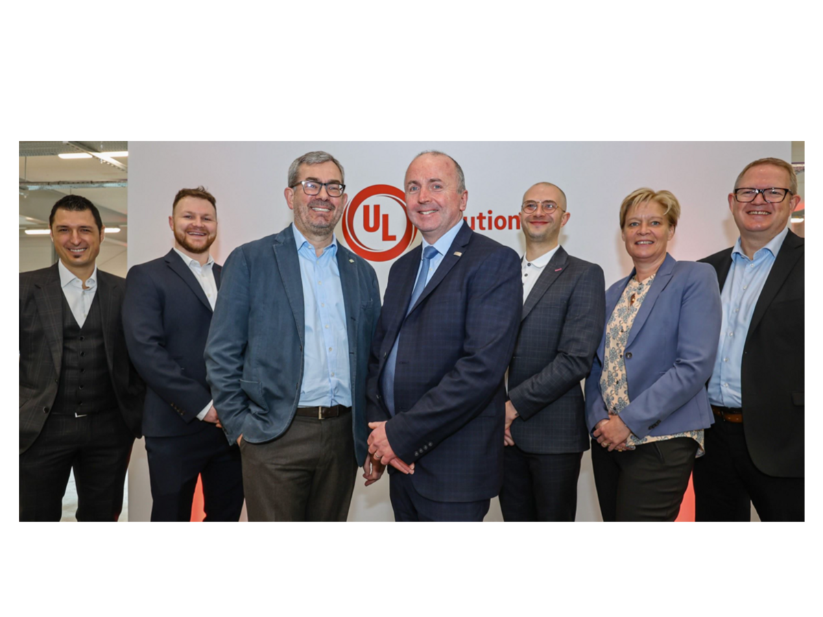 Leadership pictured in front of white wall with UL Solutions logo