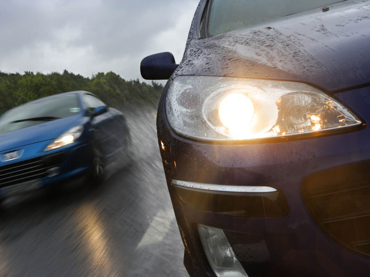 Two cars driving in the rain