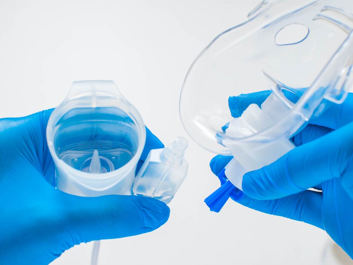 A young healthcare worker is preparing an asthma nebulizer.