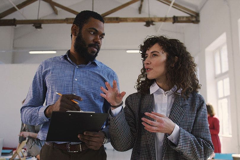 Quelqu'un en recherche d'emploi et un responsable du recrutement parlent dans un open space