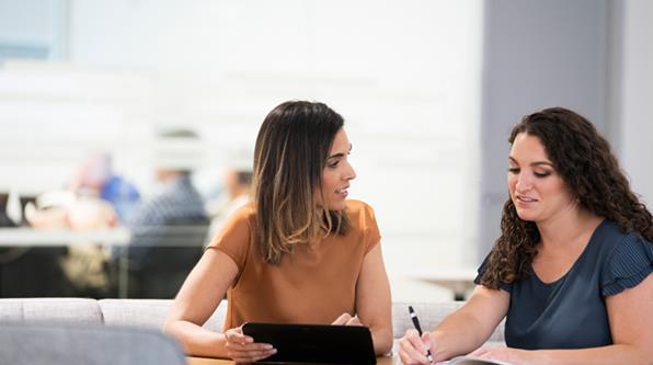 Two people writing down interview tips