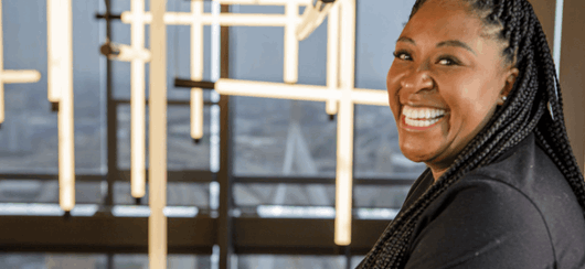 Woman Working At Computer In A Tech Office Space Smiling