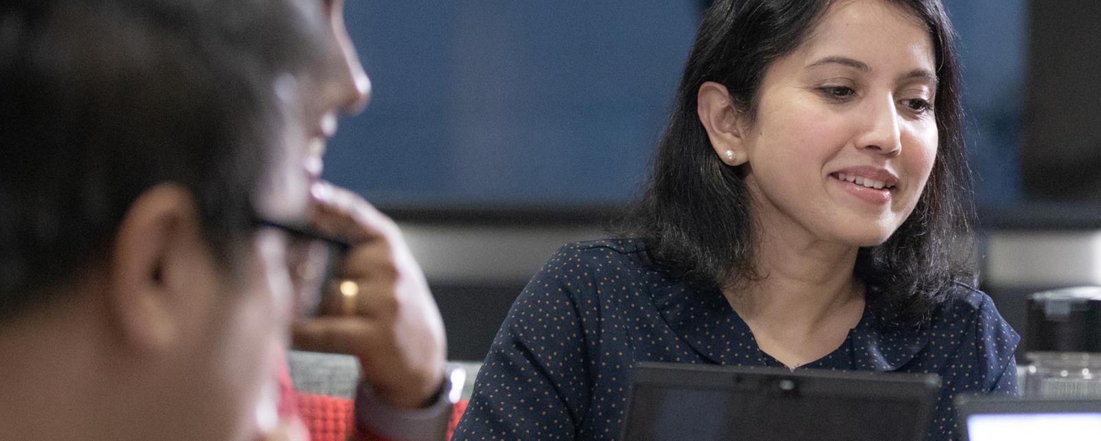 Woman Looking At Coworkers Laptop