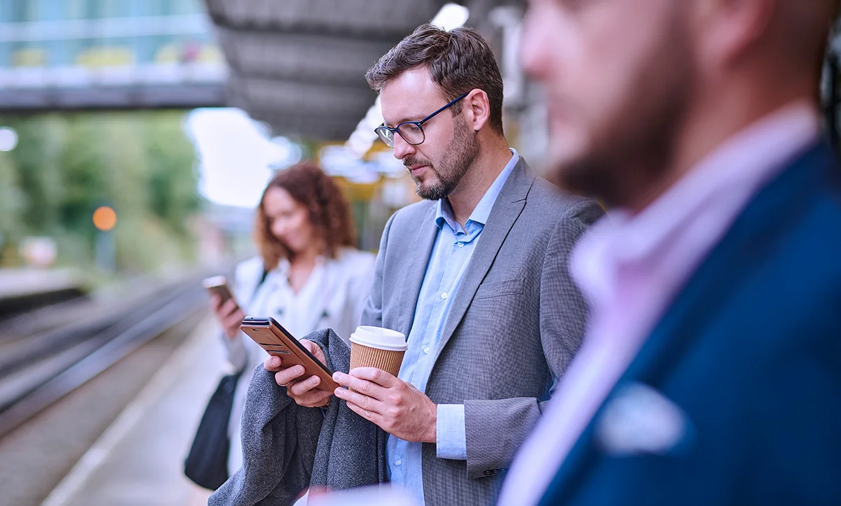 man using a smartphone at the train station