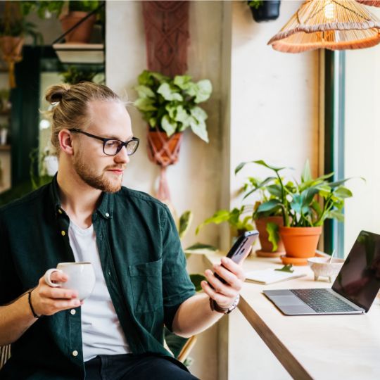 Business owner with mobile and coffee