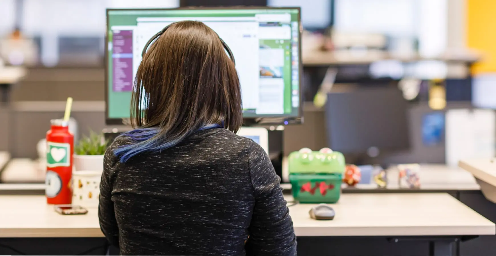 A woman sitting at a desk in front of a computer.