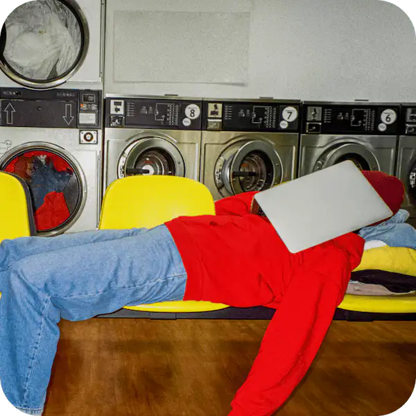 a person laying on a bench in front of a washer