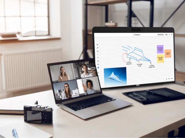 escrivaninha doméstica com notebook, quadro de compartilhamento e câmera