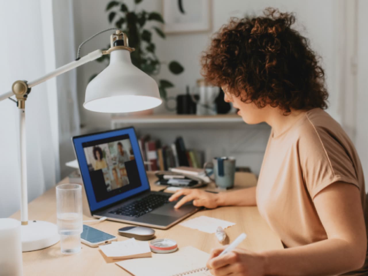 Woman working at desk with paper and laptop