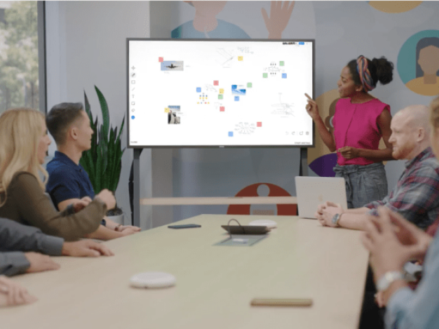 Office workers focused on whiteboard in conference room