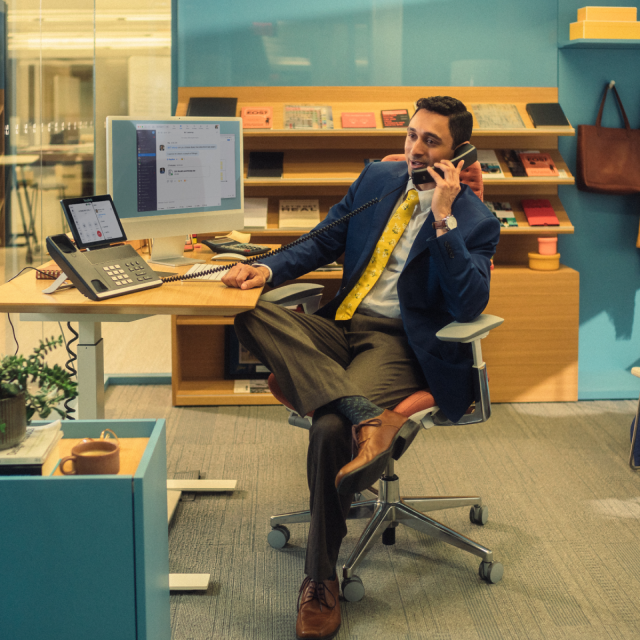 Homem sentado em uma mesa usando o telefone