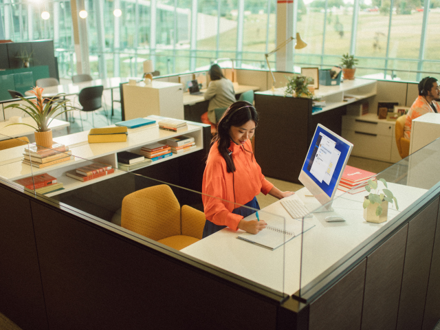 Woman writing at office desk