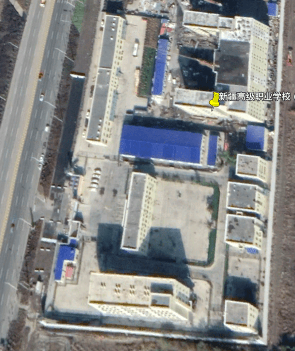 Satellite footage of a compound, showing watchtowers in the corners, as well as fencing around each building.