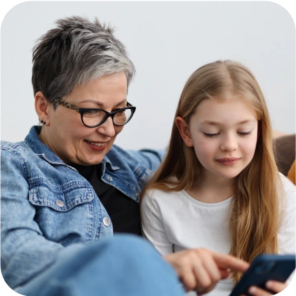 Woman and girl using smartphone together