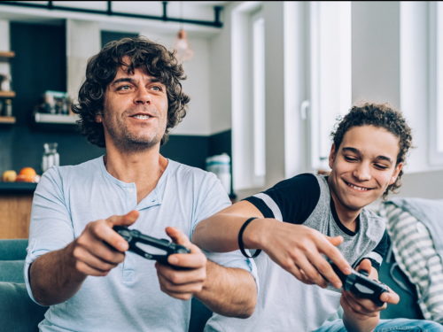 Father and son competitively gaming together on home gaming console