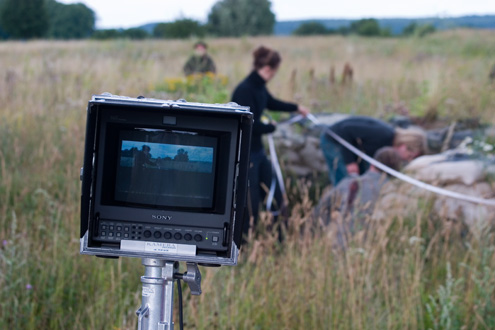 Movie monitor, while camera assistent in the background measures distance to subject.