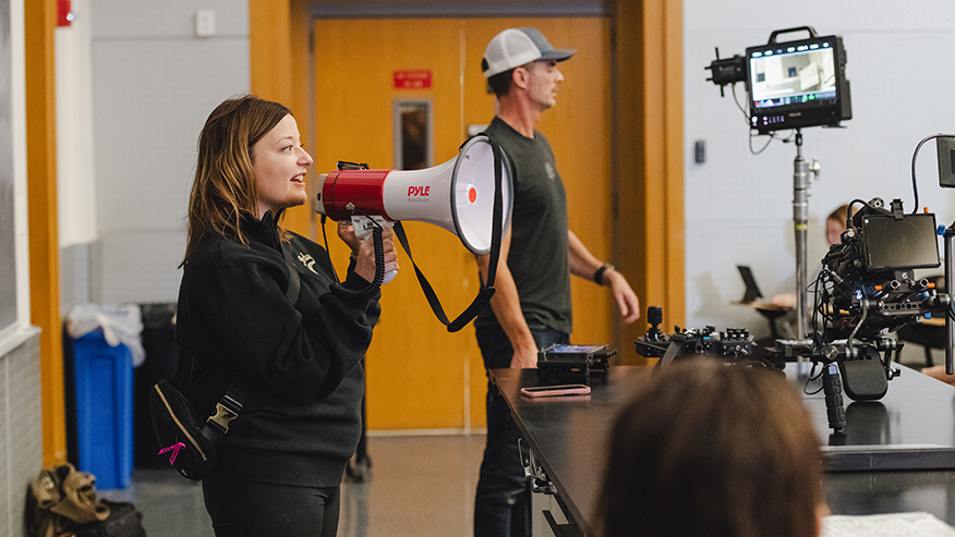 Emily Richwine, senior director of creative services for Purdue University, directs a large lecture hall of student volunteers acting as extras for a scene in “Boilers to Mars,” a new 10-minute film. (Purdue University photo/Greta Bell)