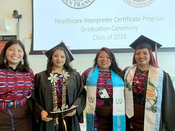 2024 Mam-speaking interpreter graduates Yosili Mendoza, Flora Cruz Ramos, Lucinda Matias, and Andrea Martin, left to right, wearing their caps and gowns.