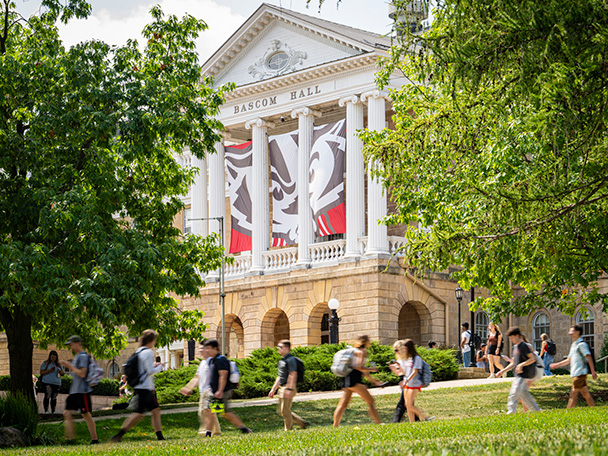 Students and pedestrians walk along Bascom Hill near Bascom Hall between class periods on a late summer day.