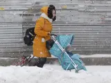 Seg&uacute;n un portavoz del servicio meteorol&oacute;gico Fobos, en Mosc&uacute; han ca&iacute;do 56 cent&iacute;metros de nieve. &quot;La &uacute;ltima vez que hab&iacute;a ca&iacute;do tanta nieve en la capital fue en marzo de 2013&quot;, ha asegurado. En la imagen, una mujer trata de atravesar la calle con un carrito de beb&eacute;.