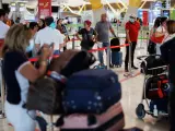 Varias personas con maletas esperando en el aeropuerto Adolfo Su&aacute;rez Madrid-Barajas, en una imagen de archivo.