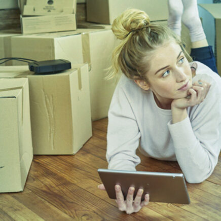 femme allongée sur le ventre avec une tablette à la main, très attentionnée