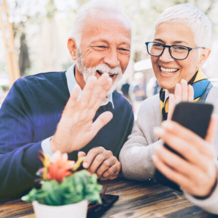 couple faisant un appel vidéo assis à une table dans l'espace public