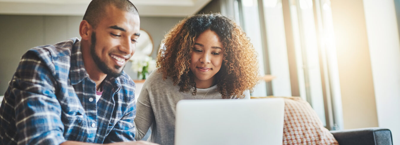 Photo d'un jeune couple utilisant un ordinateur portable tout en travaillant sur les finances de sa maison