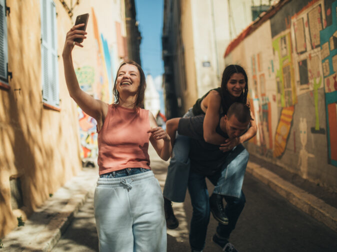 jeune homme prenant un selfie avec ses deux amis dans une rue de ville en france