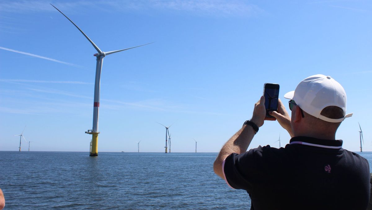 Un participant à la croisière prend en photo les éoliennes en mer de Saint-Nazaire