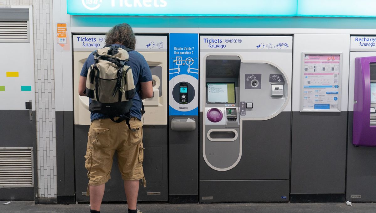 Un homme achète un titre de transport au distributeur automatique (illustration)