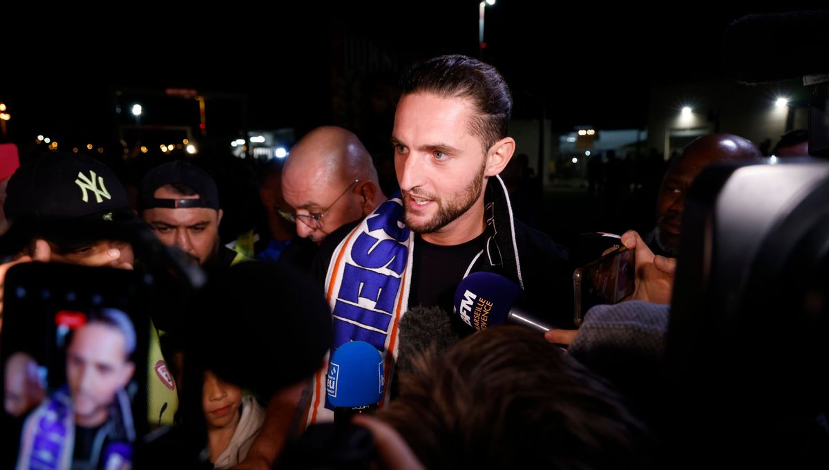 Adrien Rabiot à l'aéroport de Marignane avec une écharpe marseillaise autour du cou.