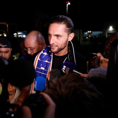 Adrien Rabiot à l'aéroport de Marignane avec une écharpe marseillaise autour du cou.