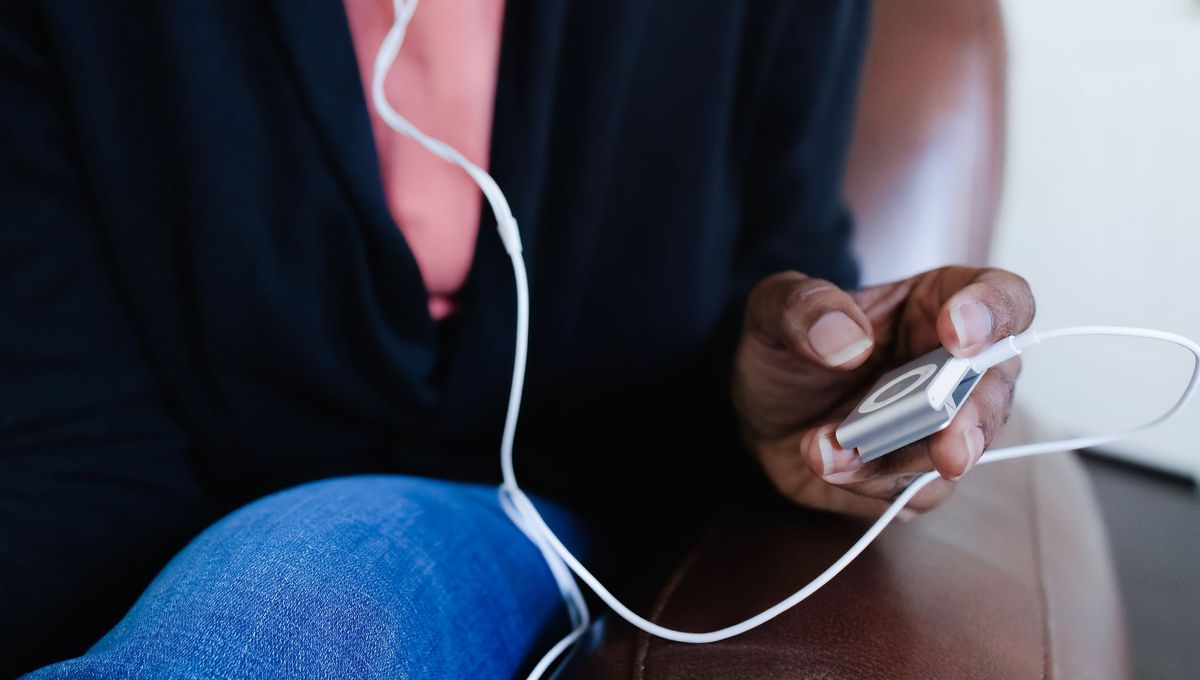 Une femme écoute de la musique sur un lecteur MP3