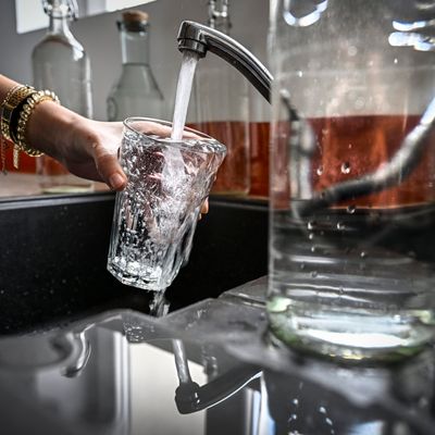 Une fremme prend de l'eau au robinet (illustration).