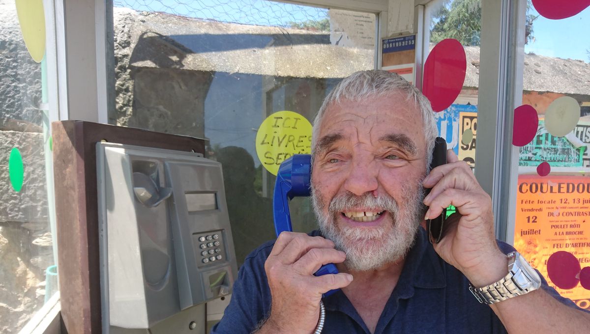 Pierre, un habitant de Payssous, dans la cabine téléphonique du village