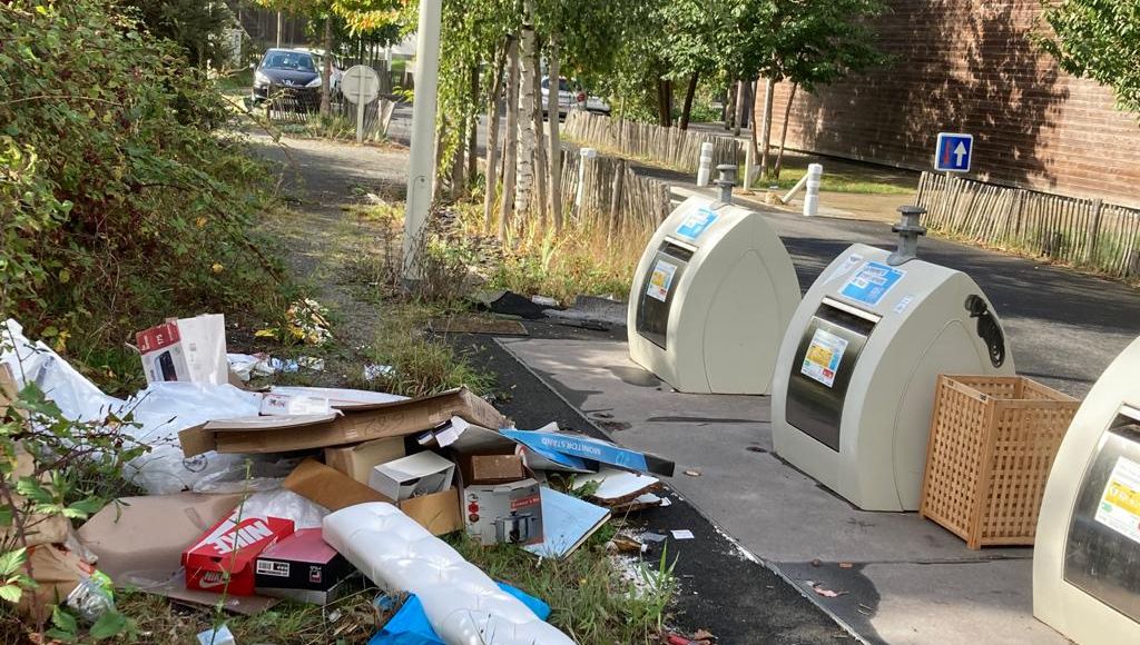 les déchets sauvages s'amoncèlent sur le trottoir aux cotés des containers enfouis 