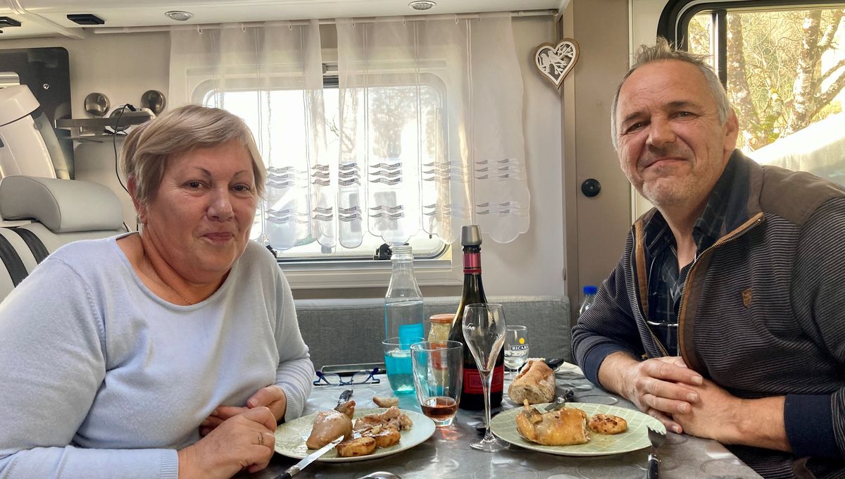 Didier et Henriette dégustent leur repas de Noël dans leur camping-car. 