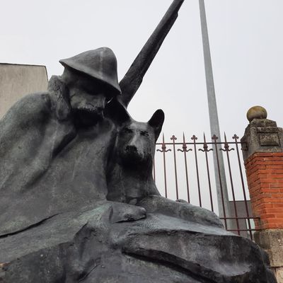 La stèle représente un poilu avec son chien sous une cape. 