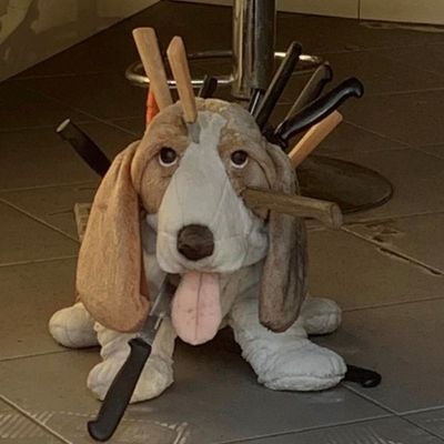 Une peluche de chien de chasse avec de nombreux couteaux plantés à l'intérieur