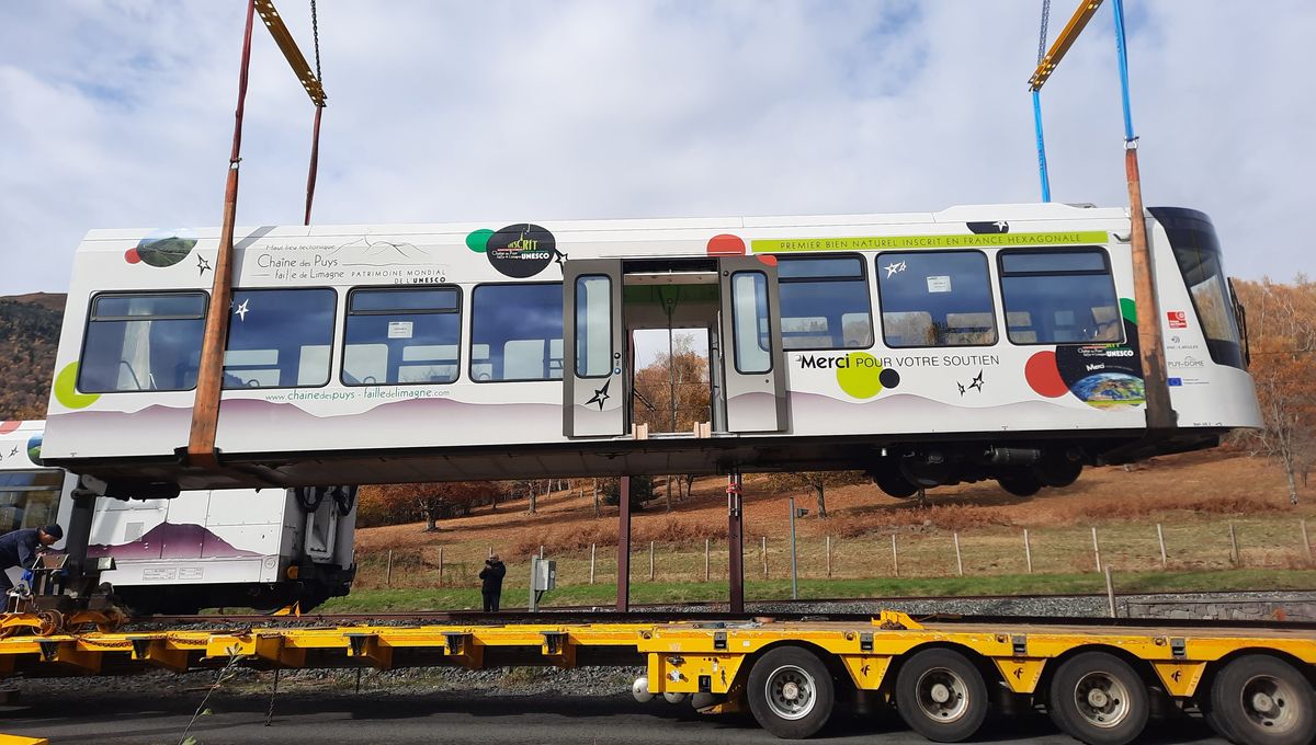 La première voiture du Panoramique des Dômes soulevée jusqu'à la remorque routière