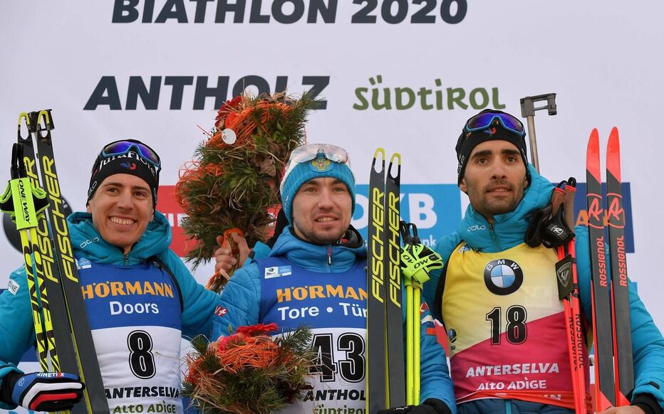  Aleksandr Loginov entouré de Quentin Fillon Maillet et Martin Fourcade. (Photo by Tiziana FABI / AFP)