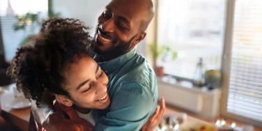 Un père et sa fille riants dans la cuisine