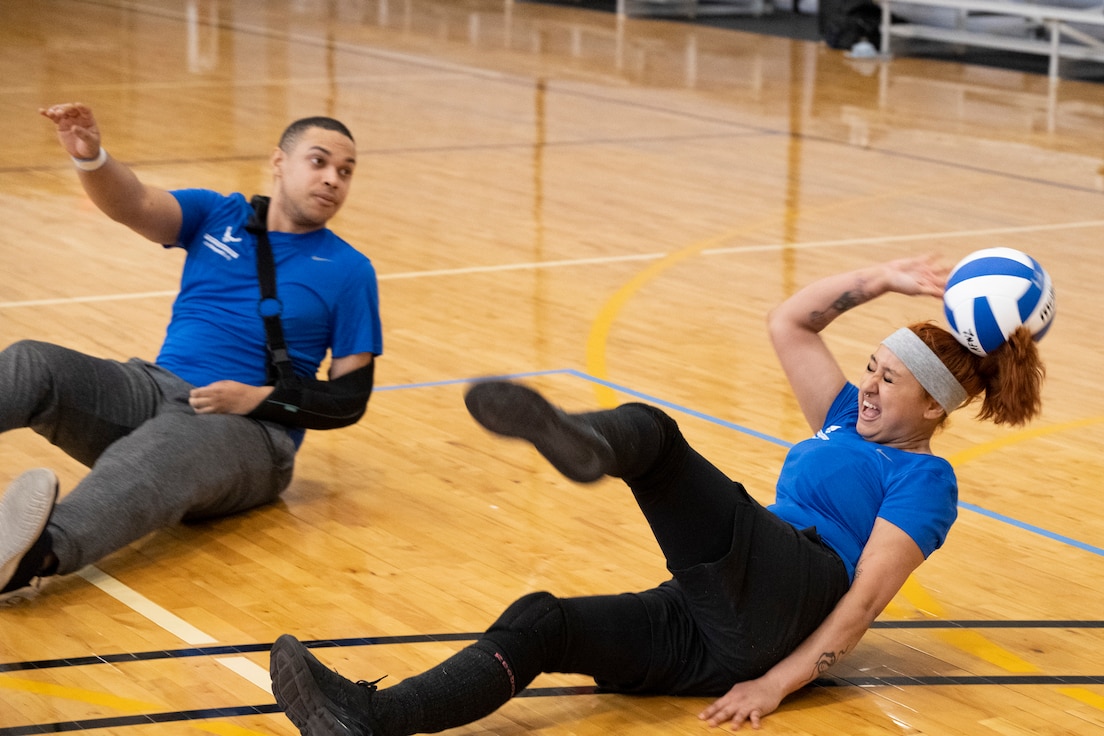 A woman tries to play a volleyball near her head.