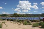 Solar panels under a partially-clouded sky in Colorado.