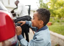 A little boy plugs in an EV charger