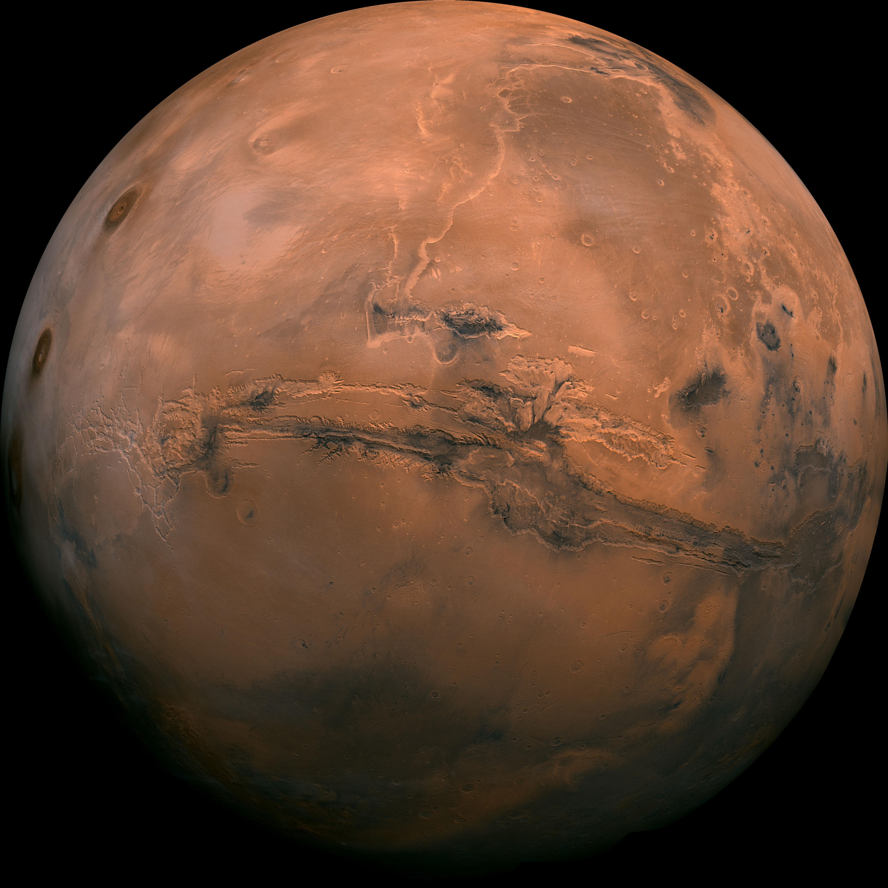 A full globe view of reddish Mars featuring Valles Marineris - which looks like a huge gash on the planet.