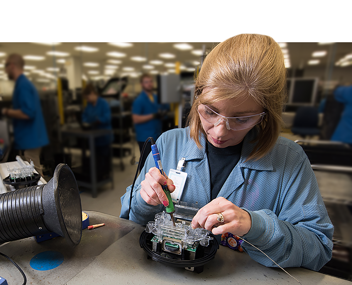 A man wearing safety goggles leans over a scientific device.