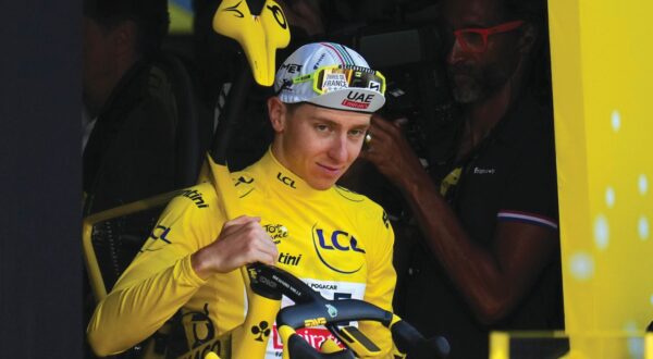 Tour de France winner Slovenia's Tadej Pogacar, wearing the overall leader's yellow jersey, walk to the podium after the twenty-first stage of the Tour de France cycling race, an individual time trial over 33.7 kilometers (20.9 miles) with start in Monaco and finish in Nice, France, Sunday, July 21, 2024. (AP Photo/Daniel Cole)