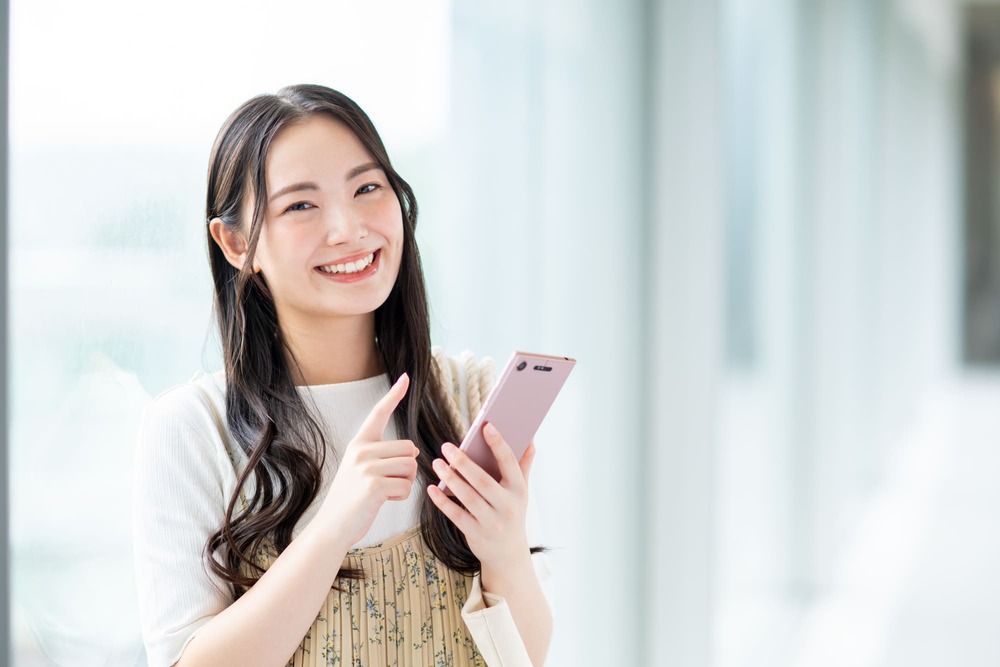 スマホを持つ笑顔の女性